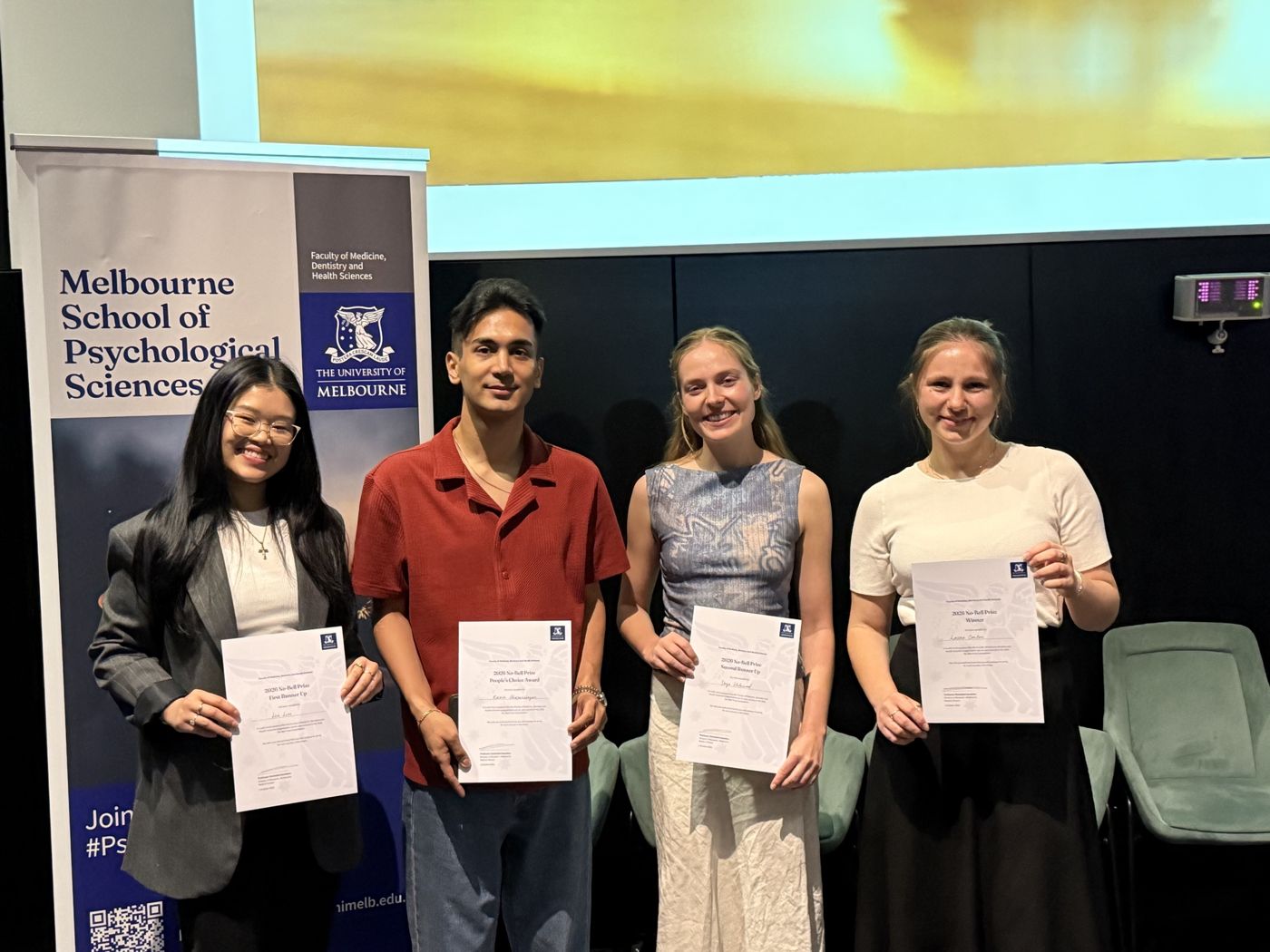 The four 2026 No-Bell Prize award recipients holding their certificates